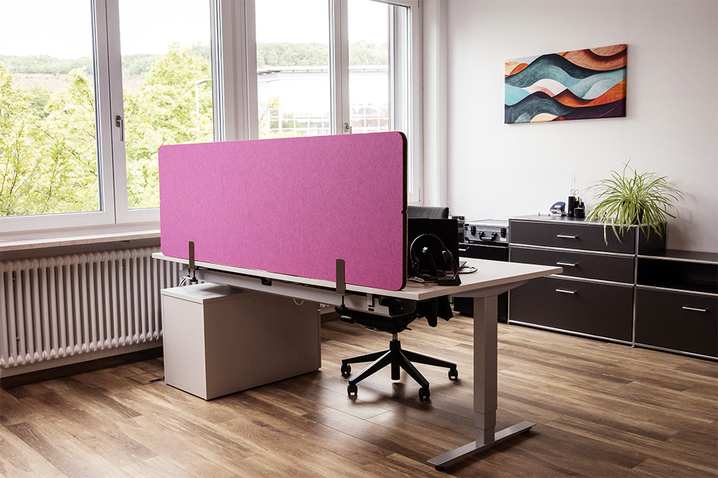 Pinke Tischtrennwand in einem Büro auf dem Schreibtisch montiert