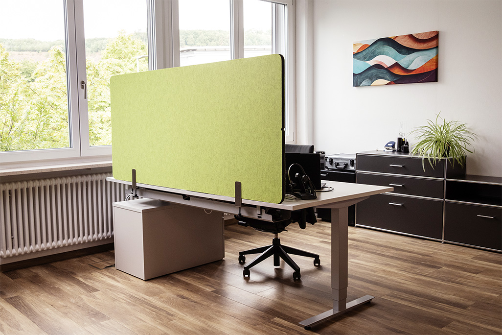 Grüne Tischtrennwand in einem Büro auf dem Schreibtisch montiert