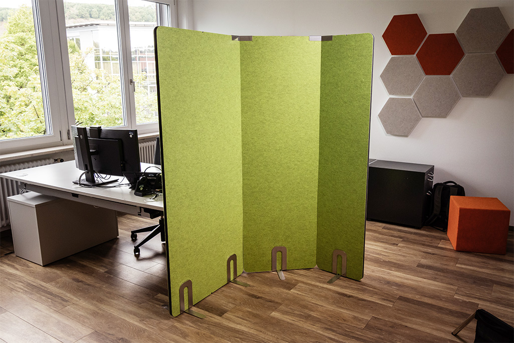Grüne Tischtrennwand in einem Büro auf dem Schreibtisch montiert