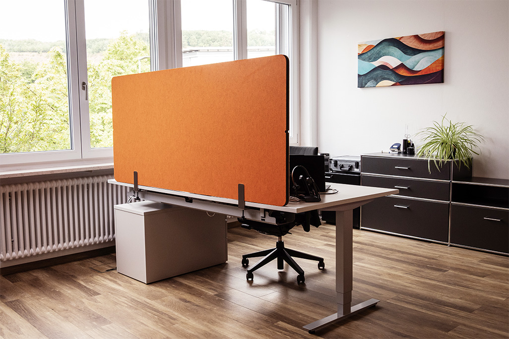 Orangene Tischtrennwand in einem Büro auf dem Schreibtisch montiert