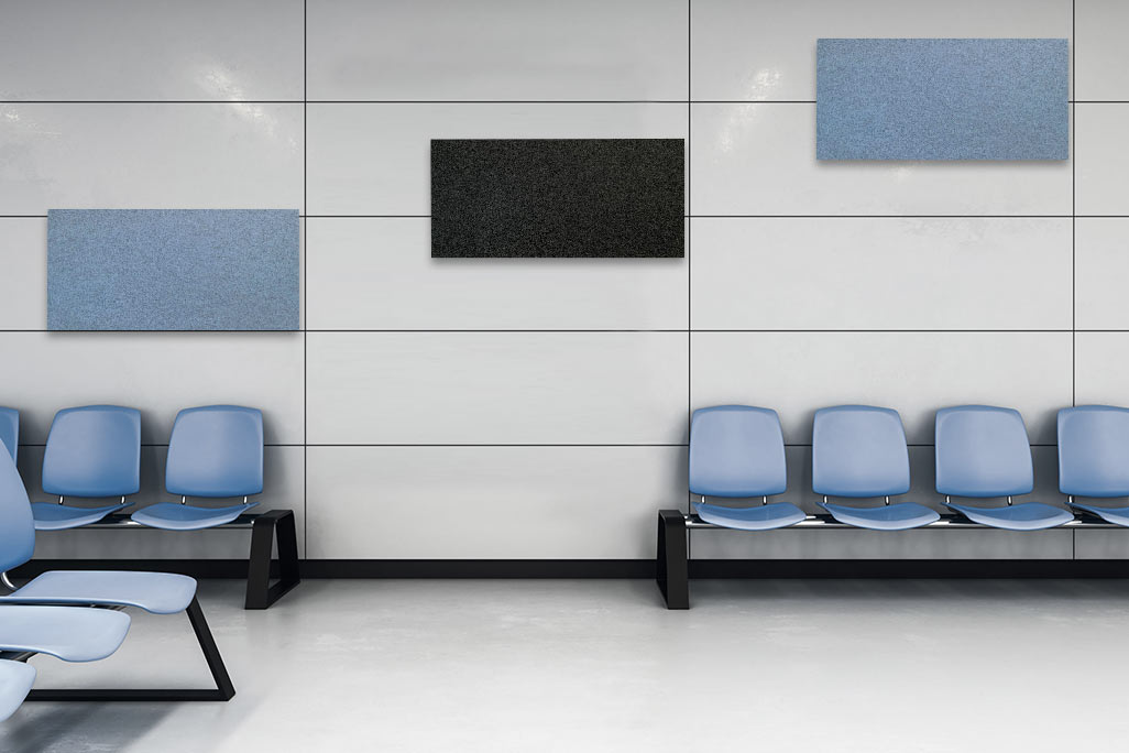 Waiting room with blue chairs and a wall showing three rectangular acoustic elements in blue and anthracite