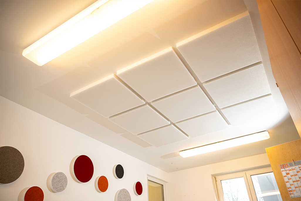 Decke mit einem 3x3 Muster aus quadratischen weißen Vliesabsorbern