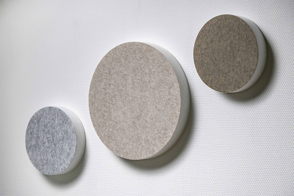 Three sound absorbers in the shape of a circle (soni ELEMENT CIRCLE) on a white wall in the colors greige, light grey and beige.