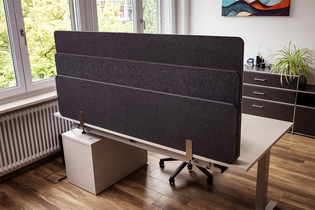 Anthrazite Tischtrennwand in einem Büro auf dem Schreibtisch montiert