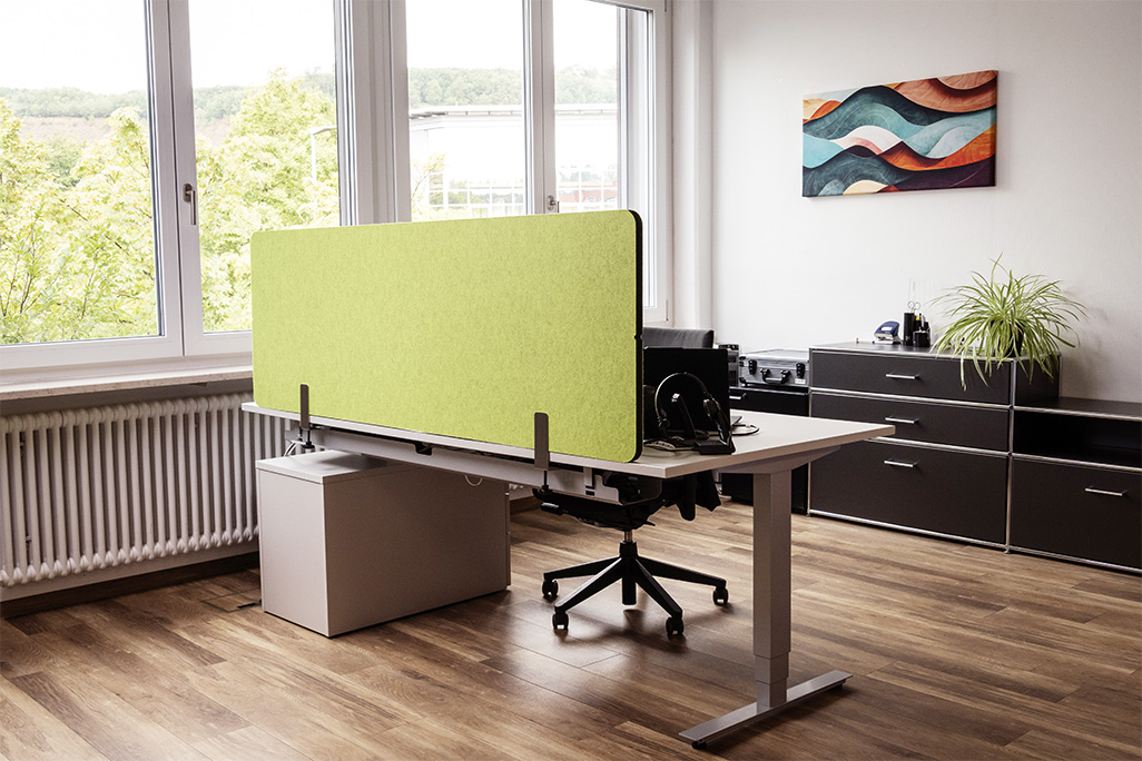 Grüne Tischtrennwand in einem Büro auf dem Schreibtisch montiert