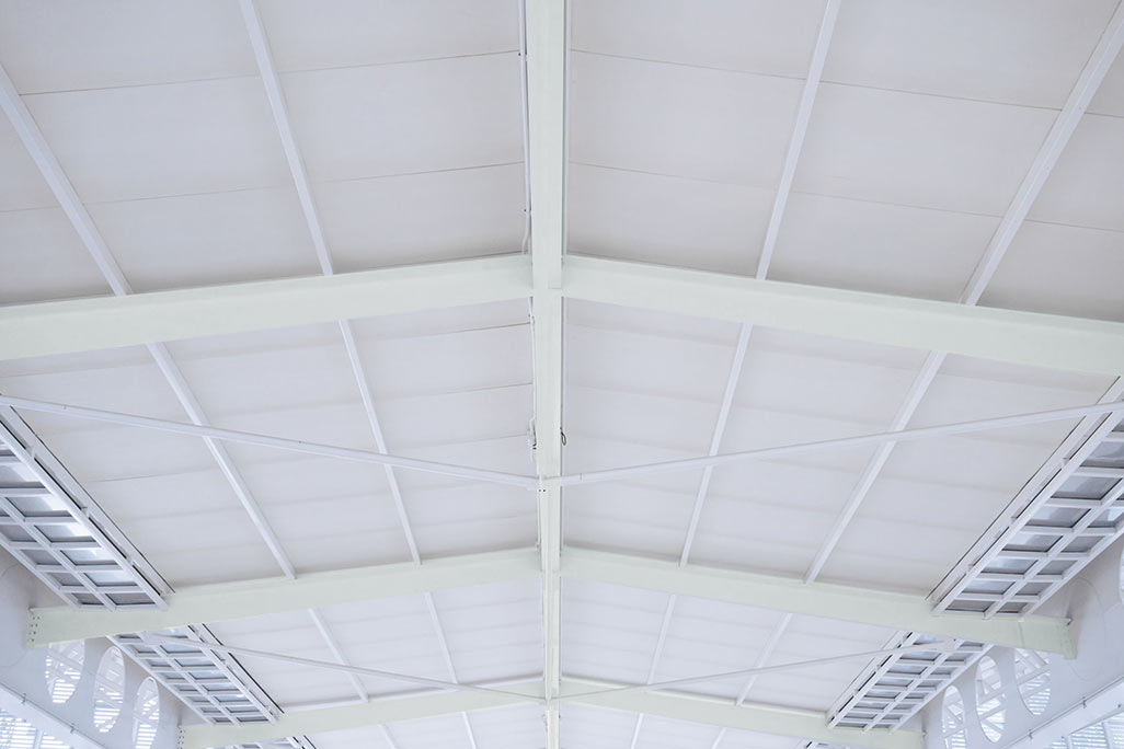 Ceiling of a gymnasium lined with white soni COMFORT sound absorption panels