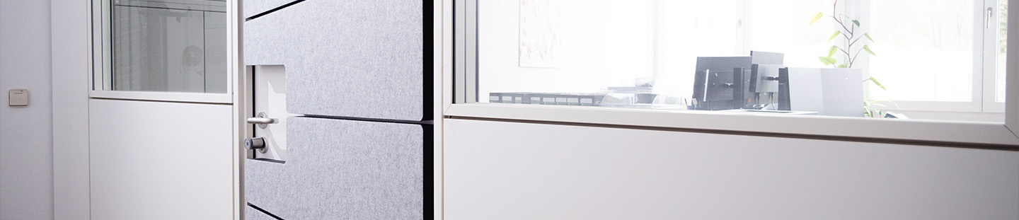 Graue Schallschutzelemente an einer Tür, montiert mit Schattenfuge