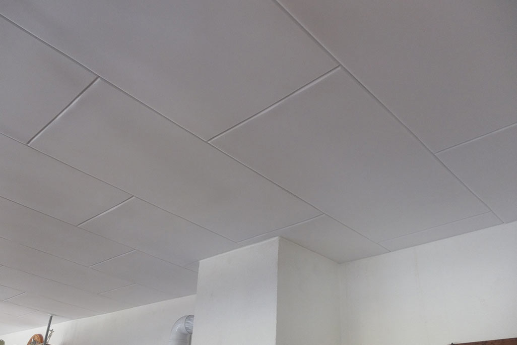 Ceiling clad with white melamine foam board for sound absorption